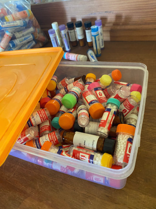 Loose homeopathic remedy tubes in a storage bin before organizing